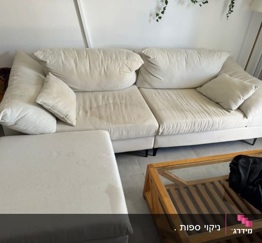 ספה בהירה עם כתמי לכלוך נראים לעין